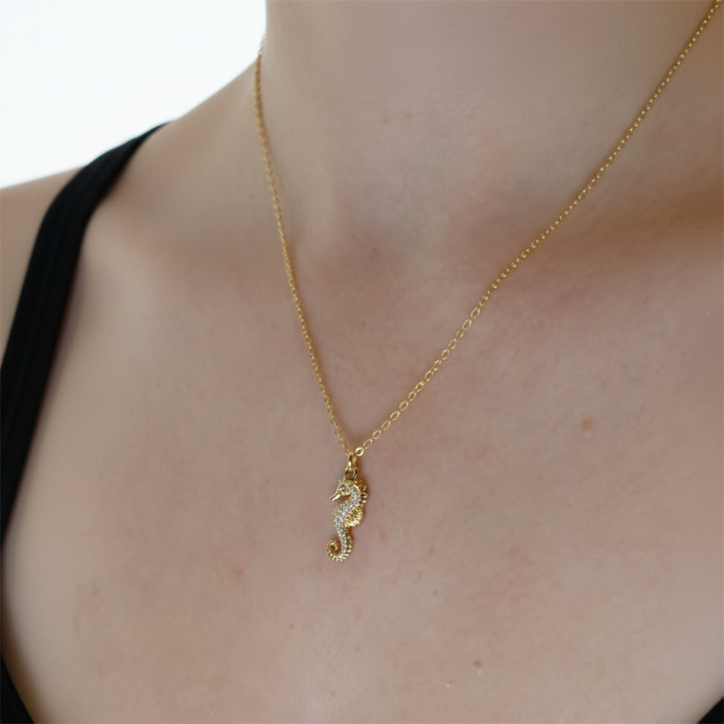 Woman wearing gold seahorse necklace showing how pendant sits on neck, ocean-inspired jewellery