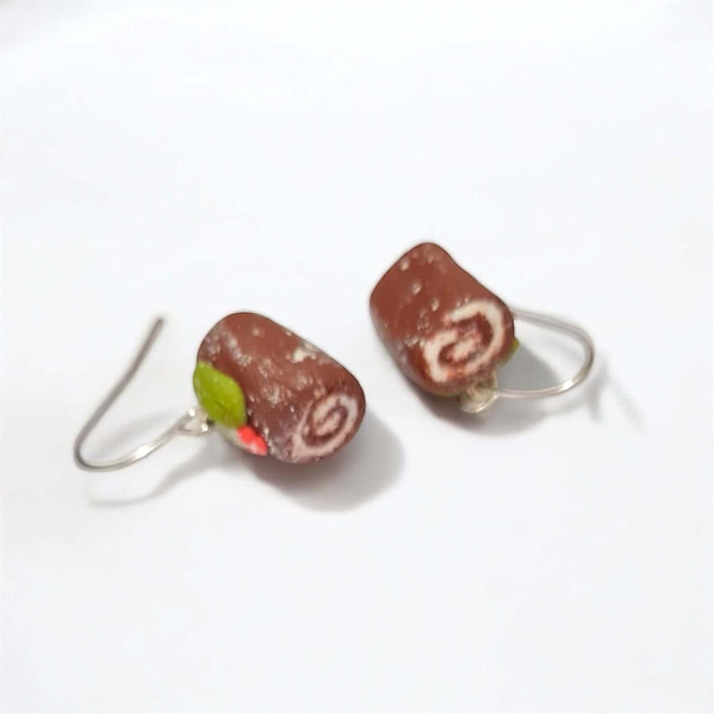 Chocolate roll-shaped earrings on a white background