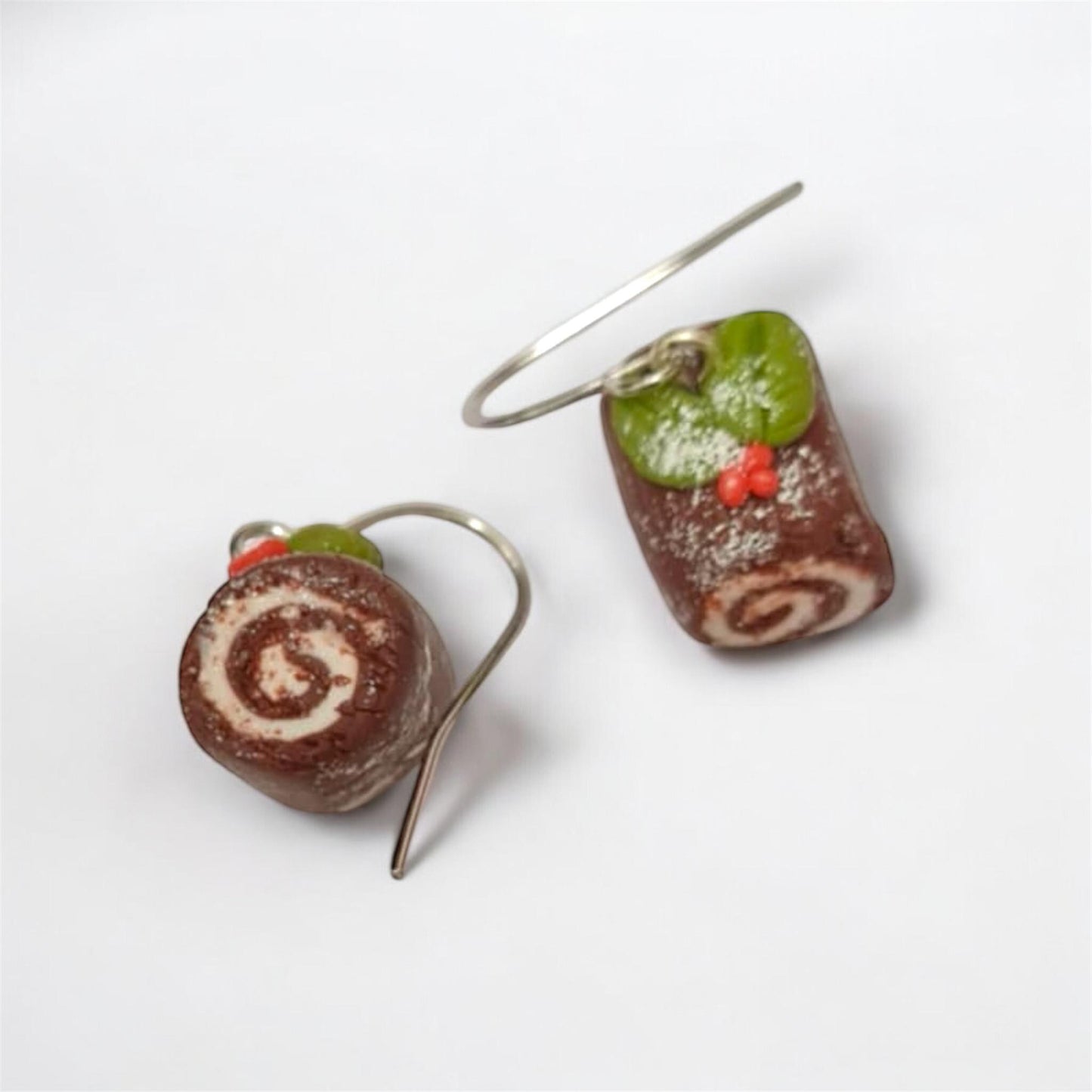 Chocolate roll cake earrings on a white background