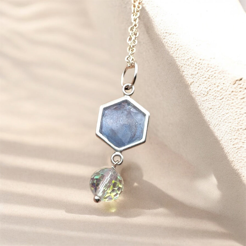 Necklace with hexagonal and round pendant on a beige background
