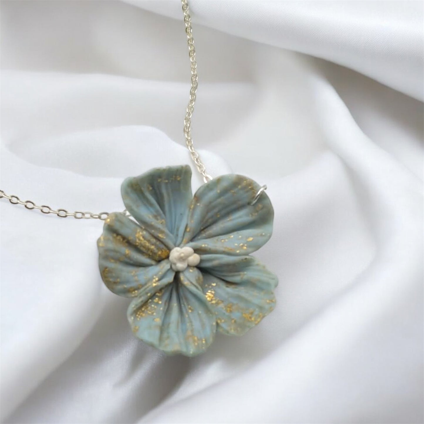 Floral necklace with gold accents on a white fabric background