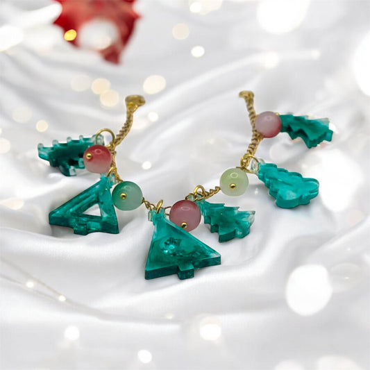 Bracelet with green tree-shaped charms on a white background