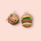 Hamburger-shaped earrings on a pink background