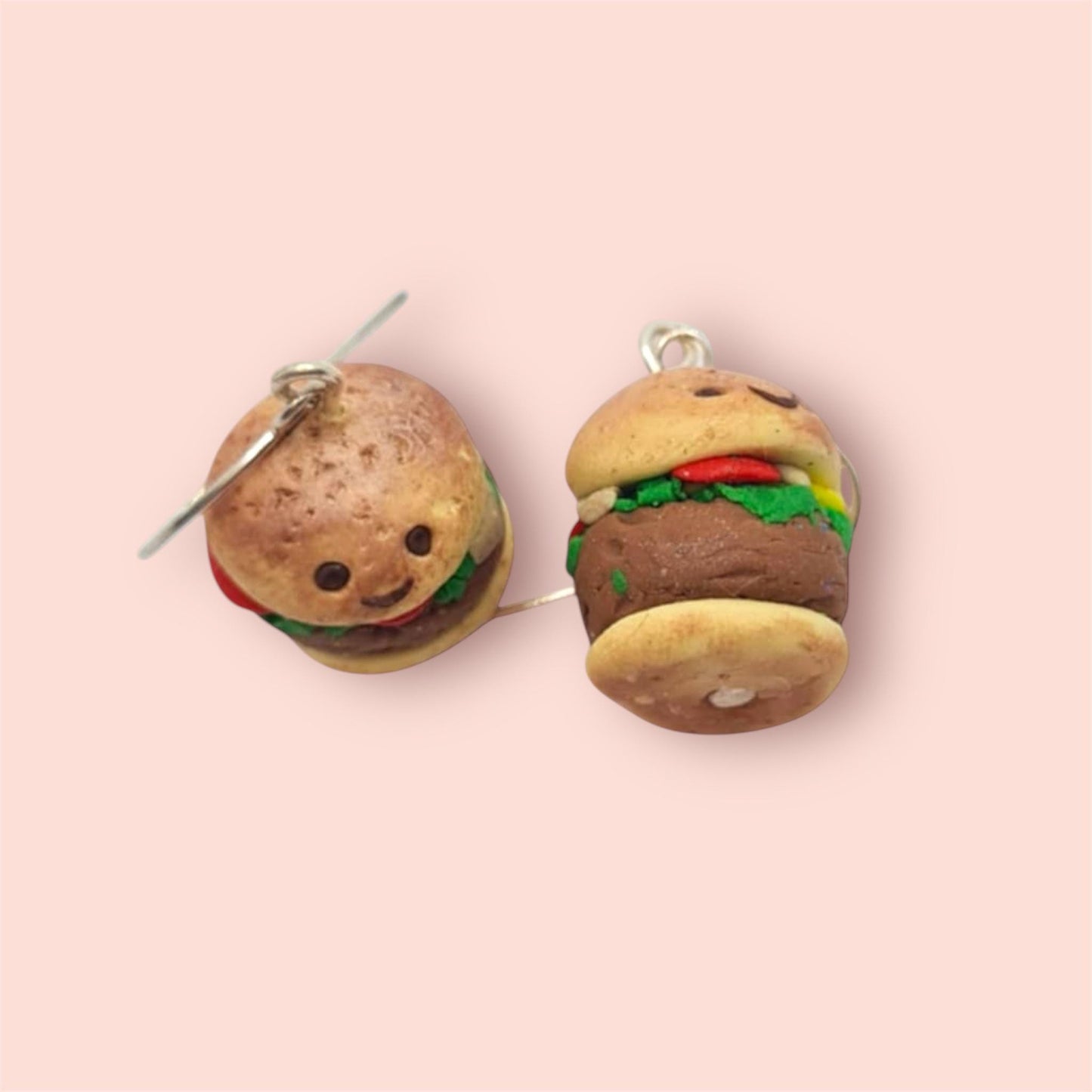 Hamburger-shaped earrings on a pink background