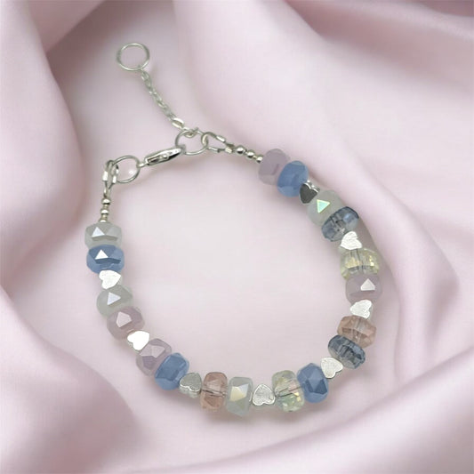 Beaded crystal bracelet with heart-shaped beads on a pink fabric background