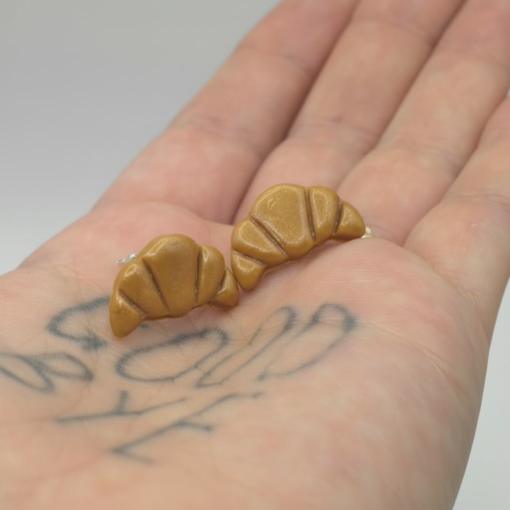 Croissant stud earrings held in hand - lightweight polymer clay jewellery
