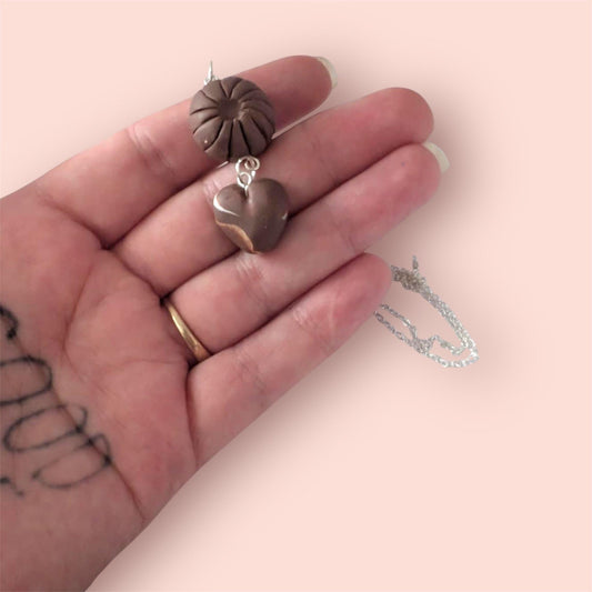 Handmade polymer clay chocolate box pendants on one necklace chain held in hand 