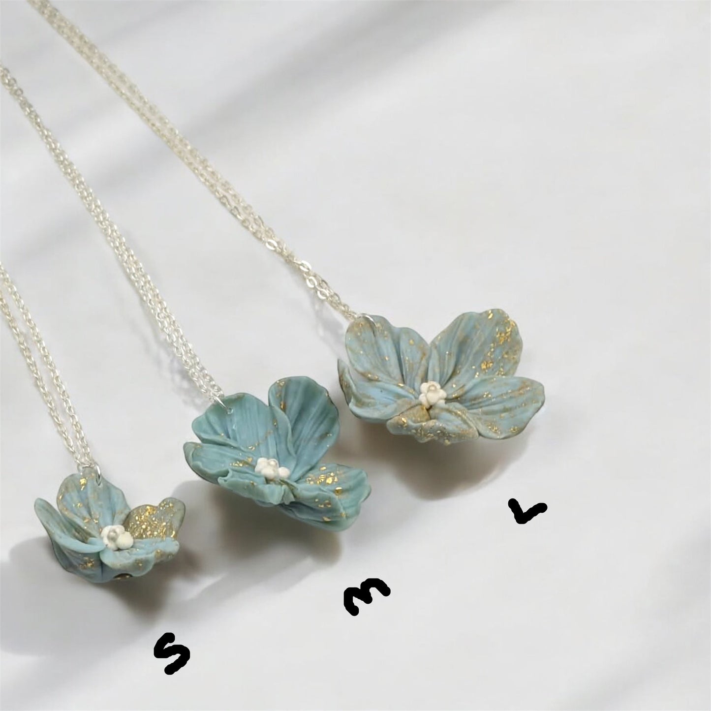 Floral necklace with light blue flower pendants on a white background