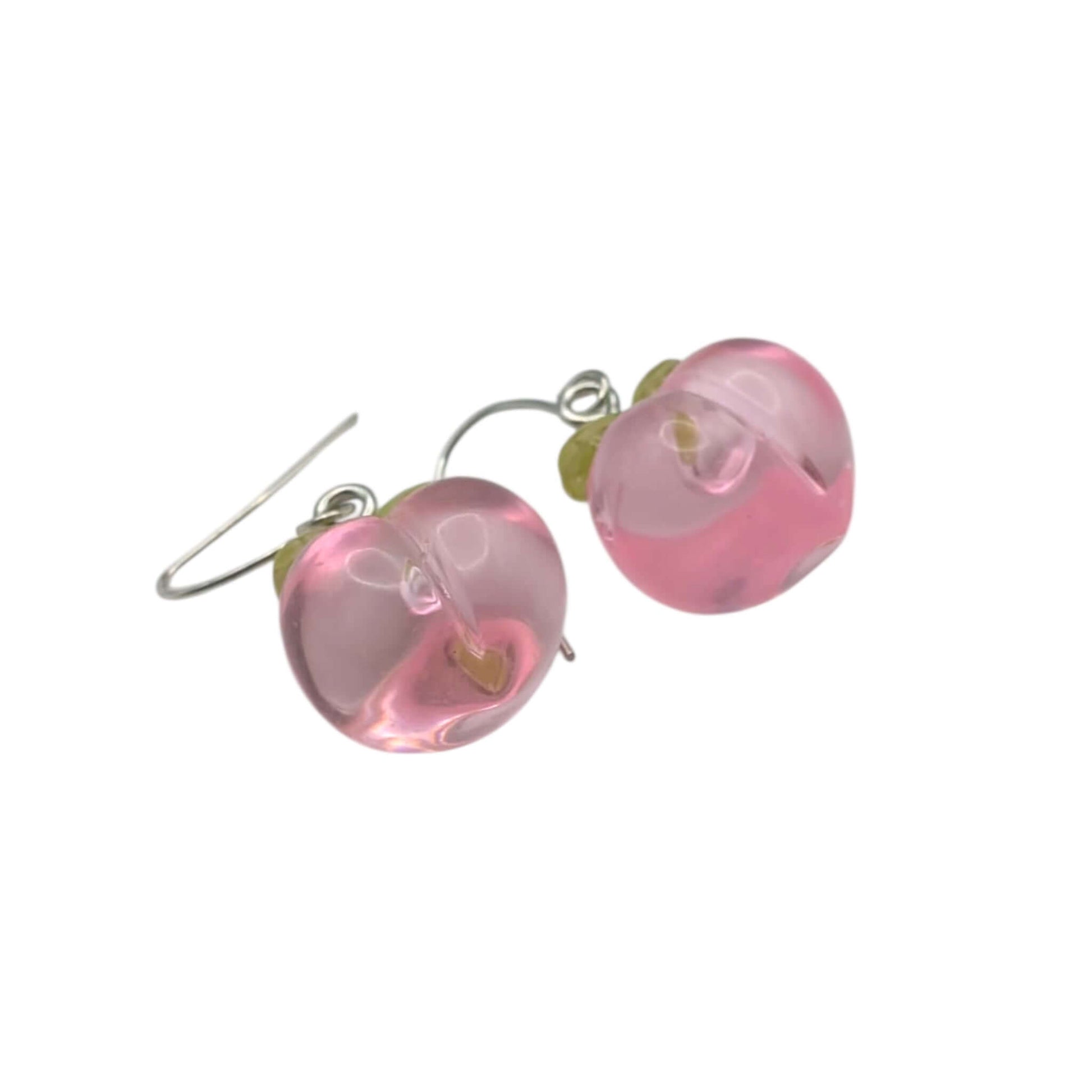 Bottom of peach earrings with silver ear wires on a white background