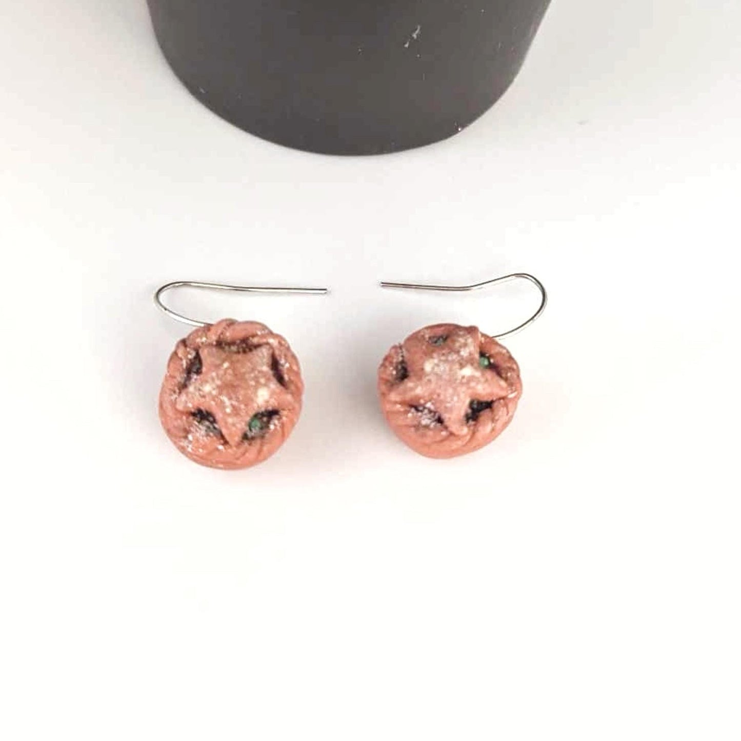 Pair of round earrings with a textured surface on a white background