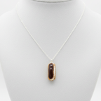 Chocolate eclair necklace side view on white background