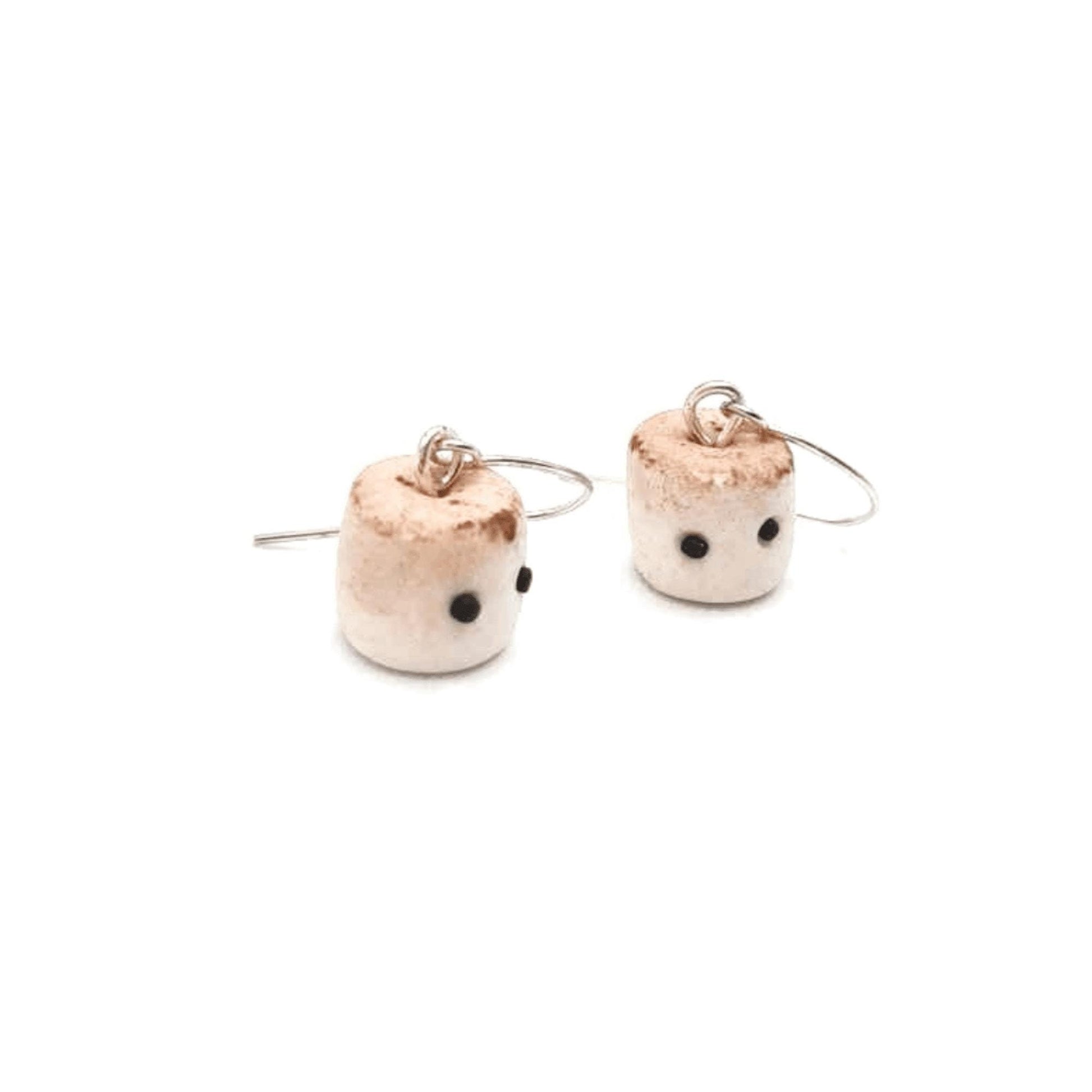 Marshmallow shaped earrings with black kawaii eyes on a white background