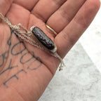 Chocolate eclair necklace close up in hand