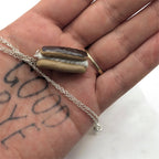 Chocolate eclair necklace on concrete prop