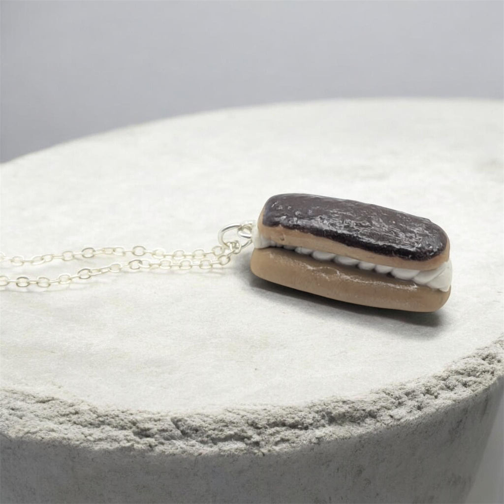 Chocolate eclair necklace on white background, angled view