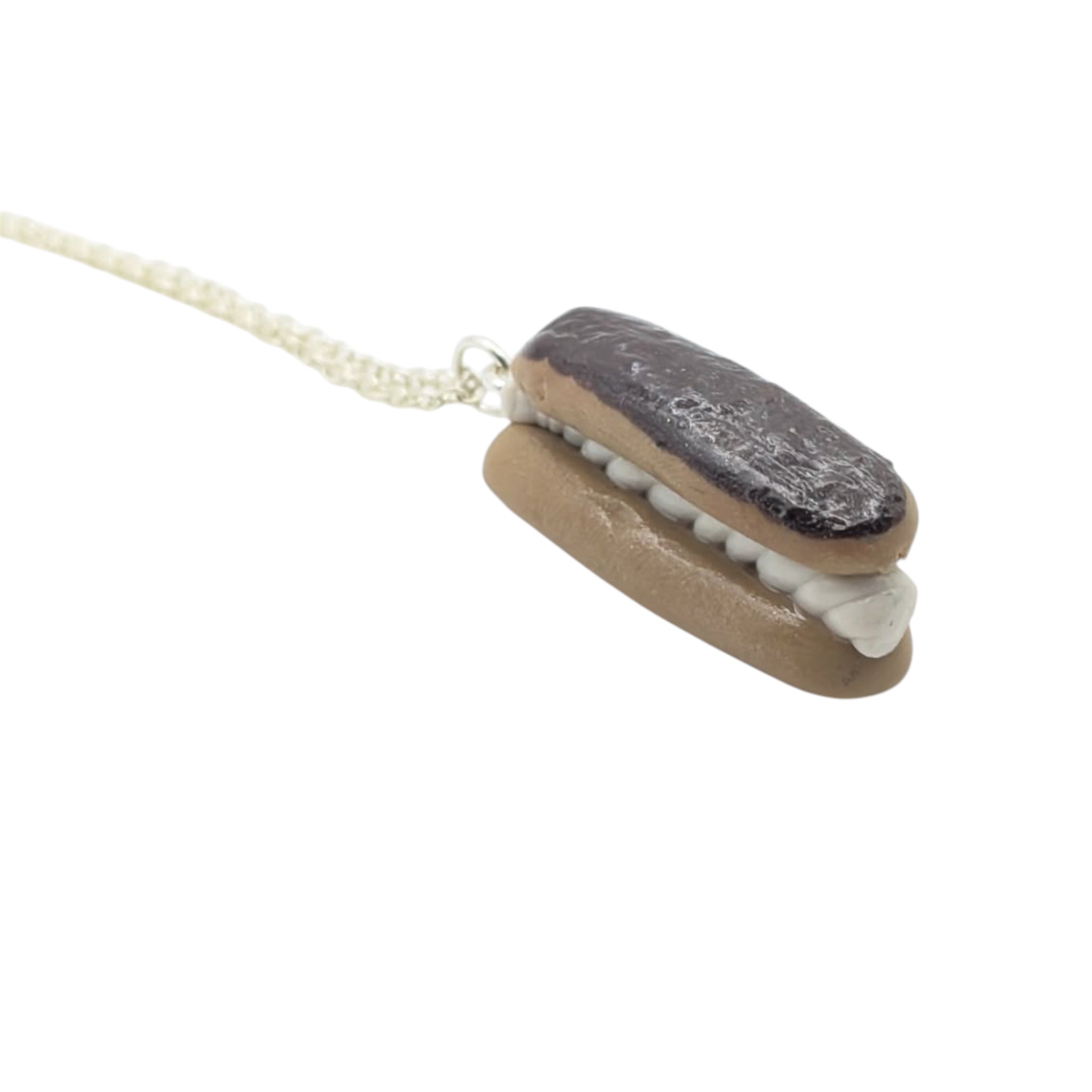 Chocolate eclair necklace held in hand showing scale