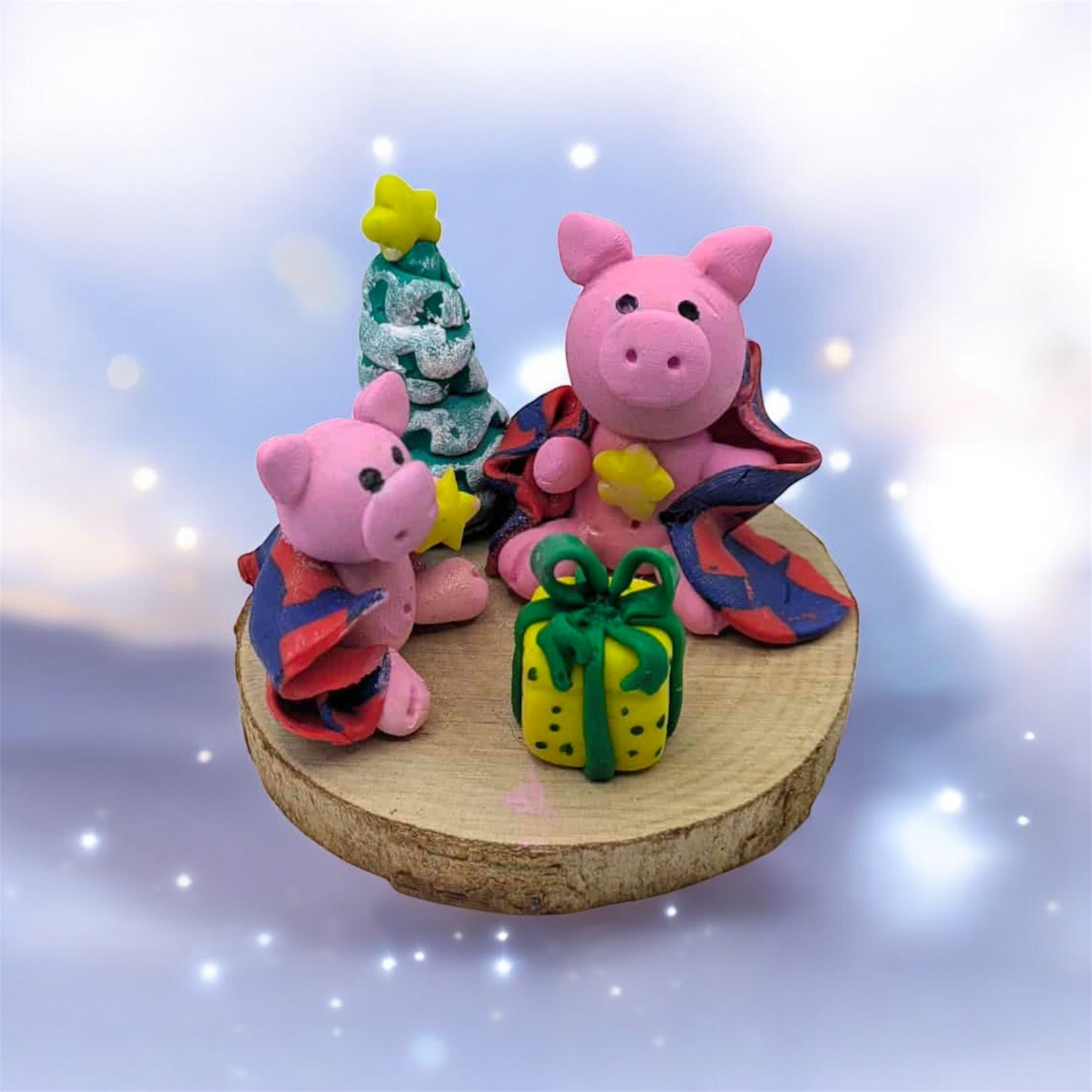 Two pink pig figurines with colorful outfits on a wooden base against a sparkling background