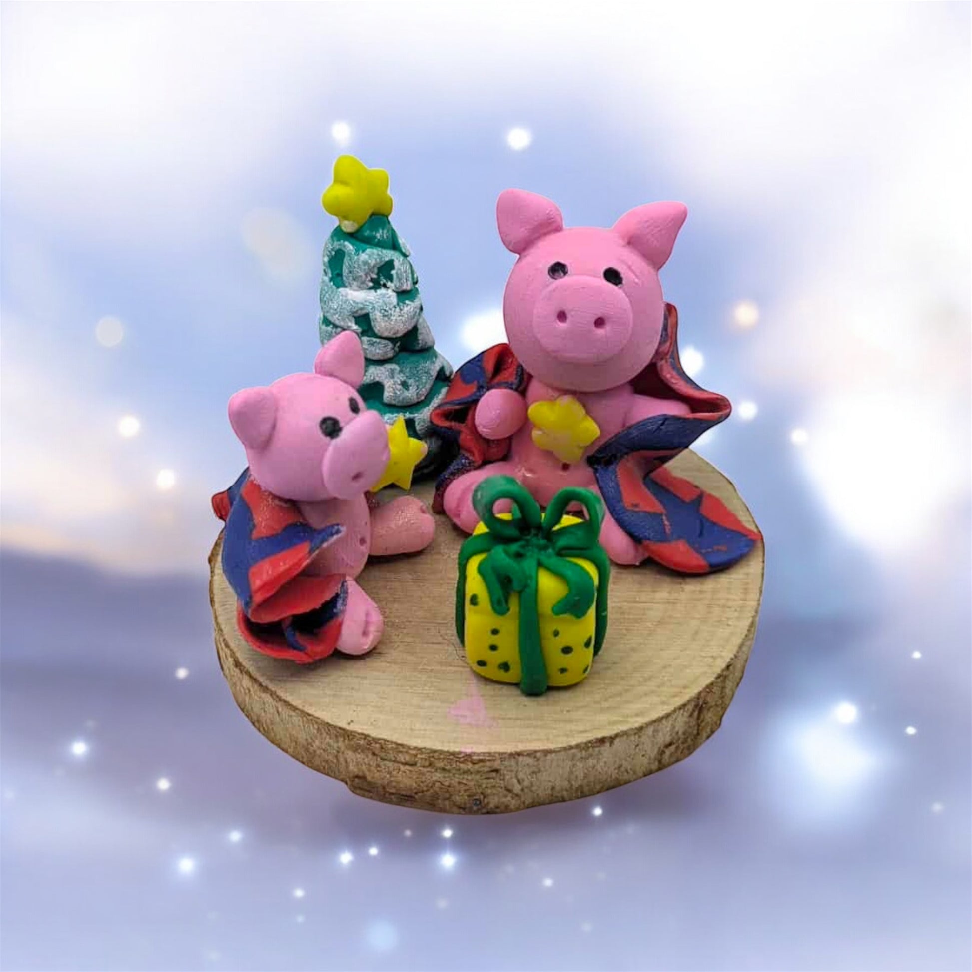 Two pink pig figurines with colorful outfits on a wooden base against a sparkling background