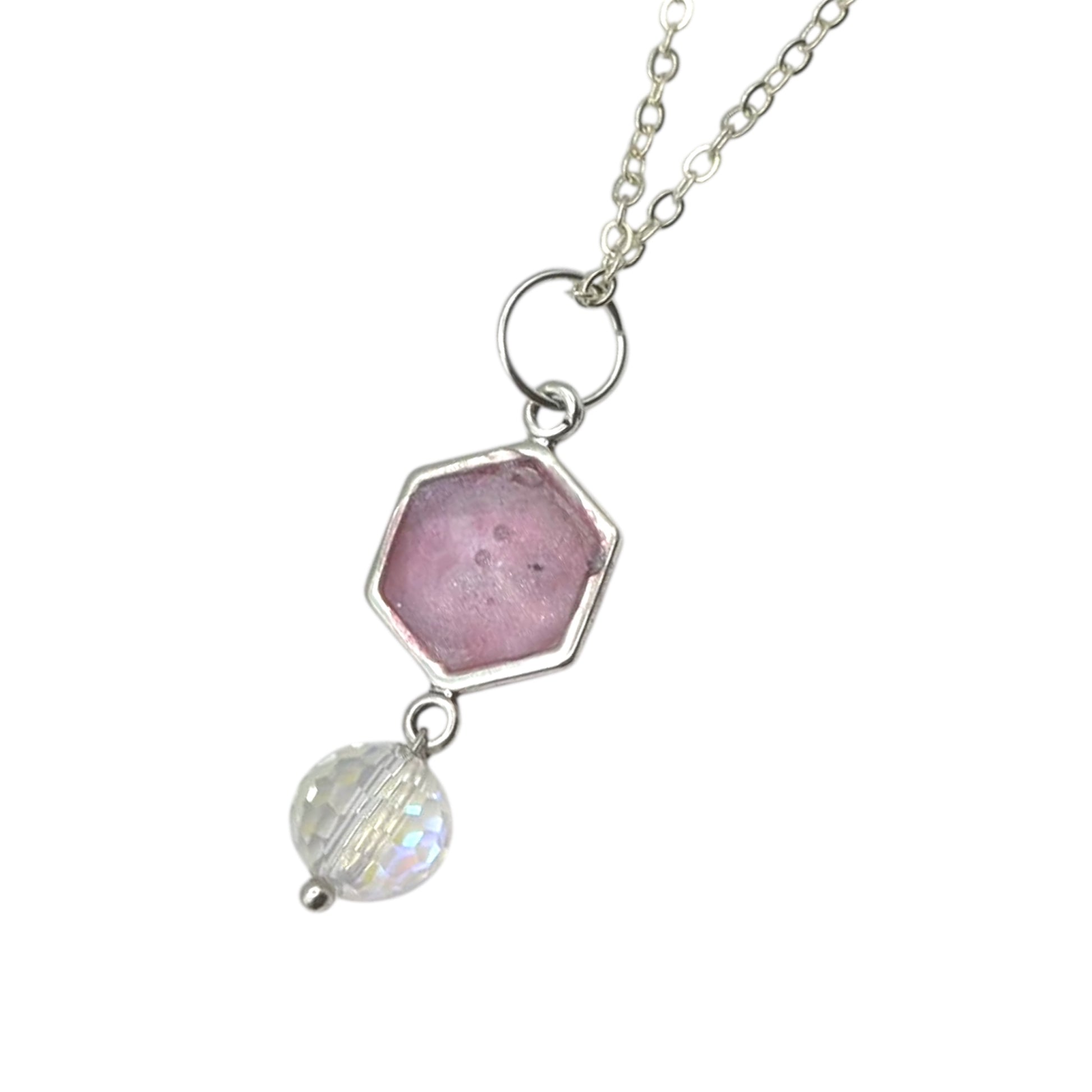 Necklace with pink hexagon and clear bead on a white background