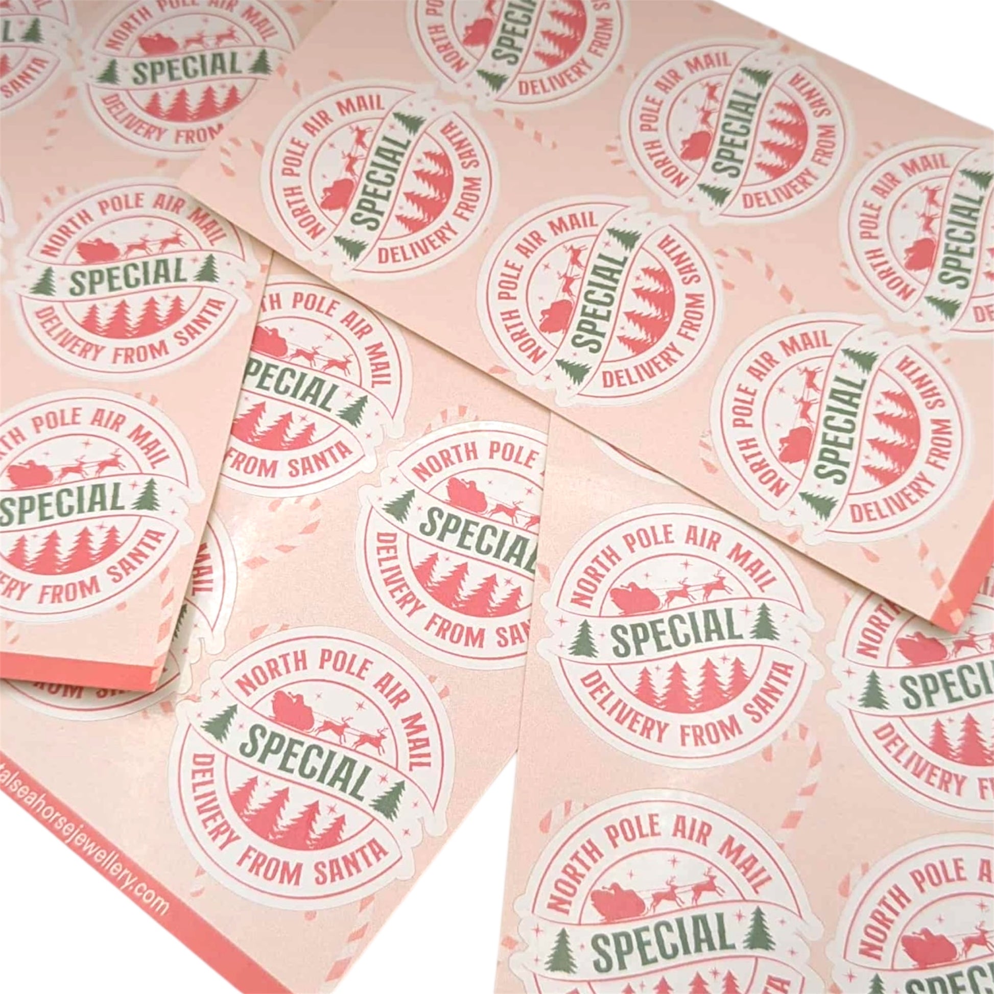 Pattern of 'Special Delivery from Santa' stickers on a pink background