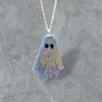 Ghost-shaped pendant on a chain against a gray marble background