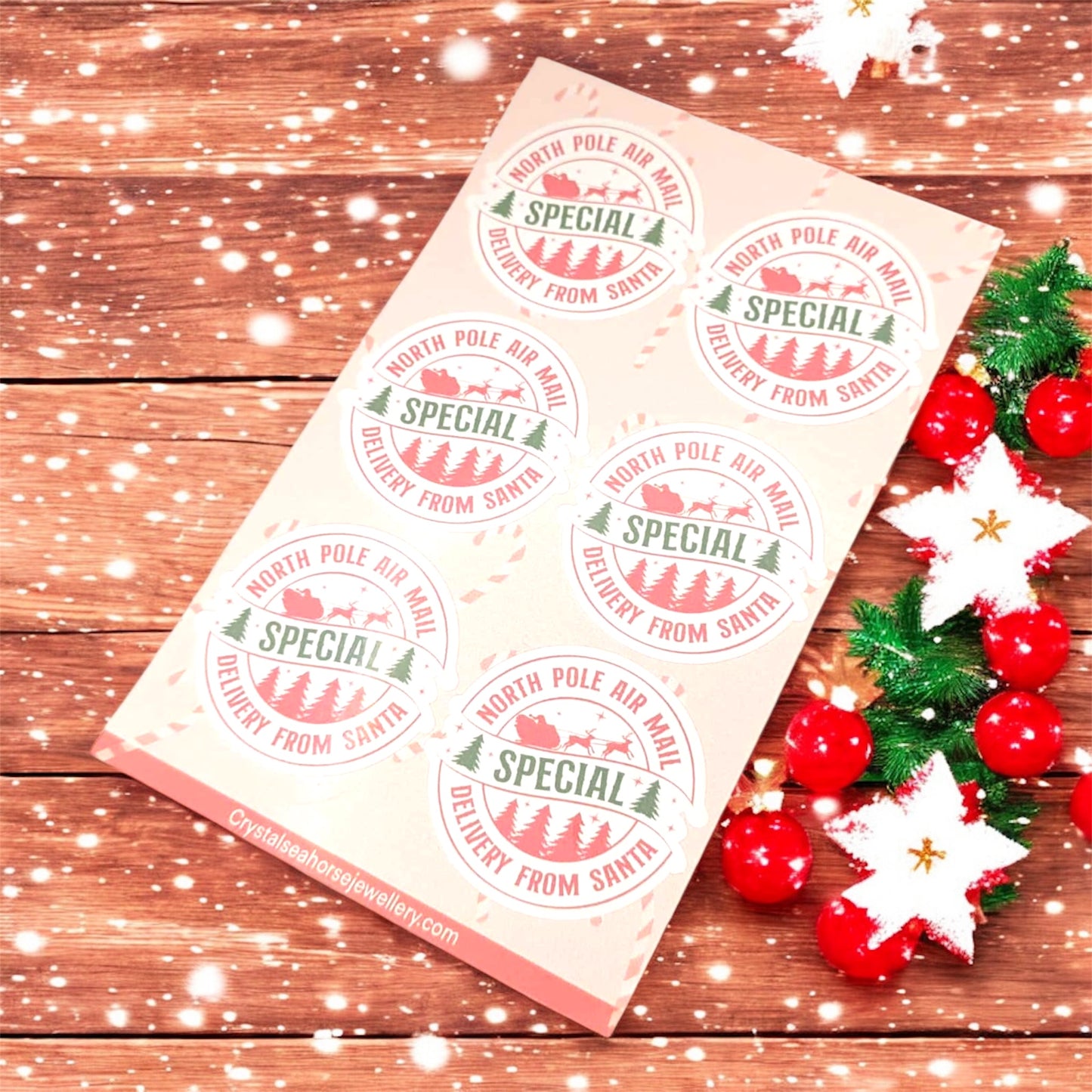 Christmas-themed stickers from Santa on a wooden surface with festive decorations.