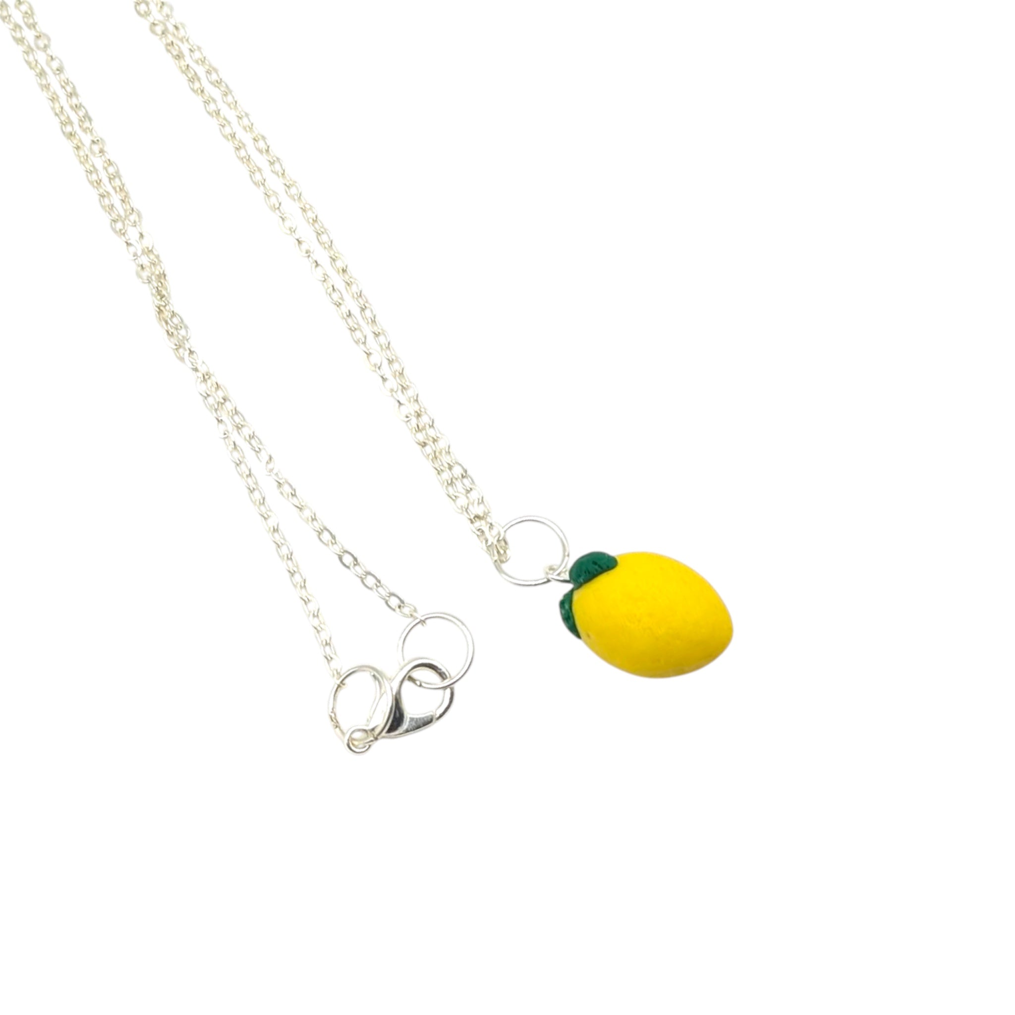 Close up yellow lemon necklace with green leave handmade polymer clay jewellery with silver chain
