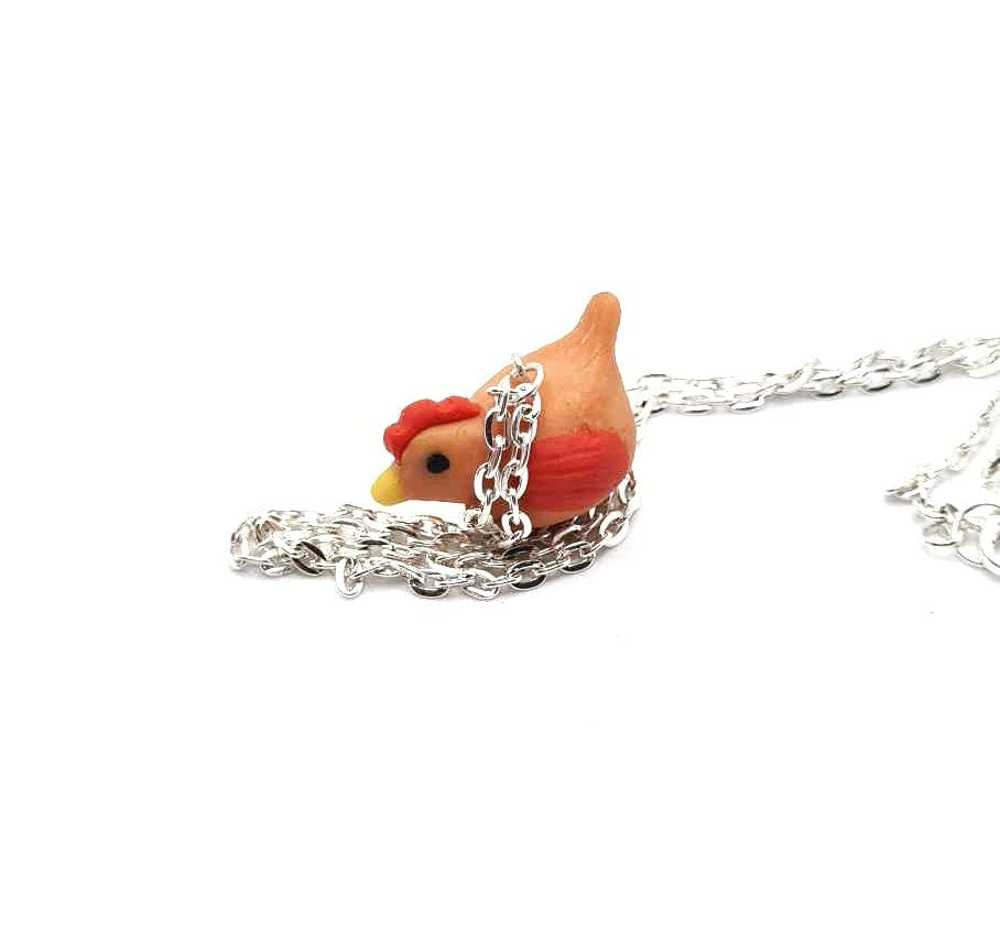 Necklace with a small red rooster pendant on a white background