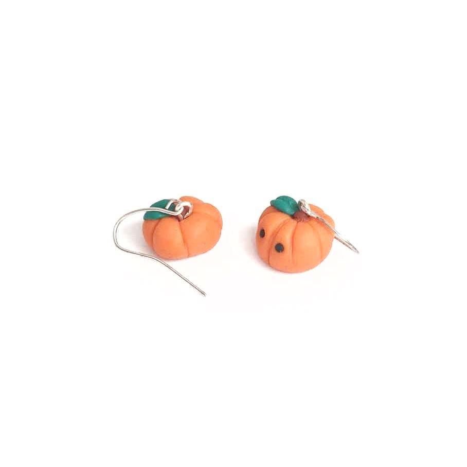 Pumpkin-shaped earrings on a white background