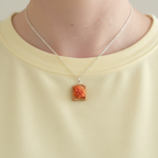 Beans on Toast Necklace worn around neck of Someone wearing a yellow shirt 