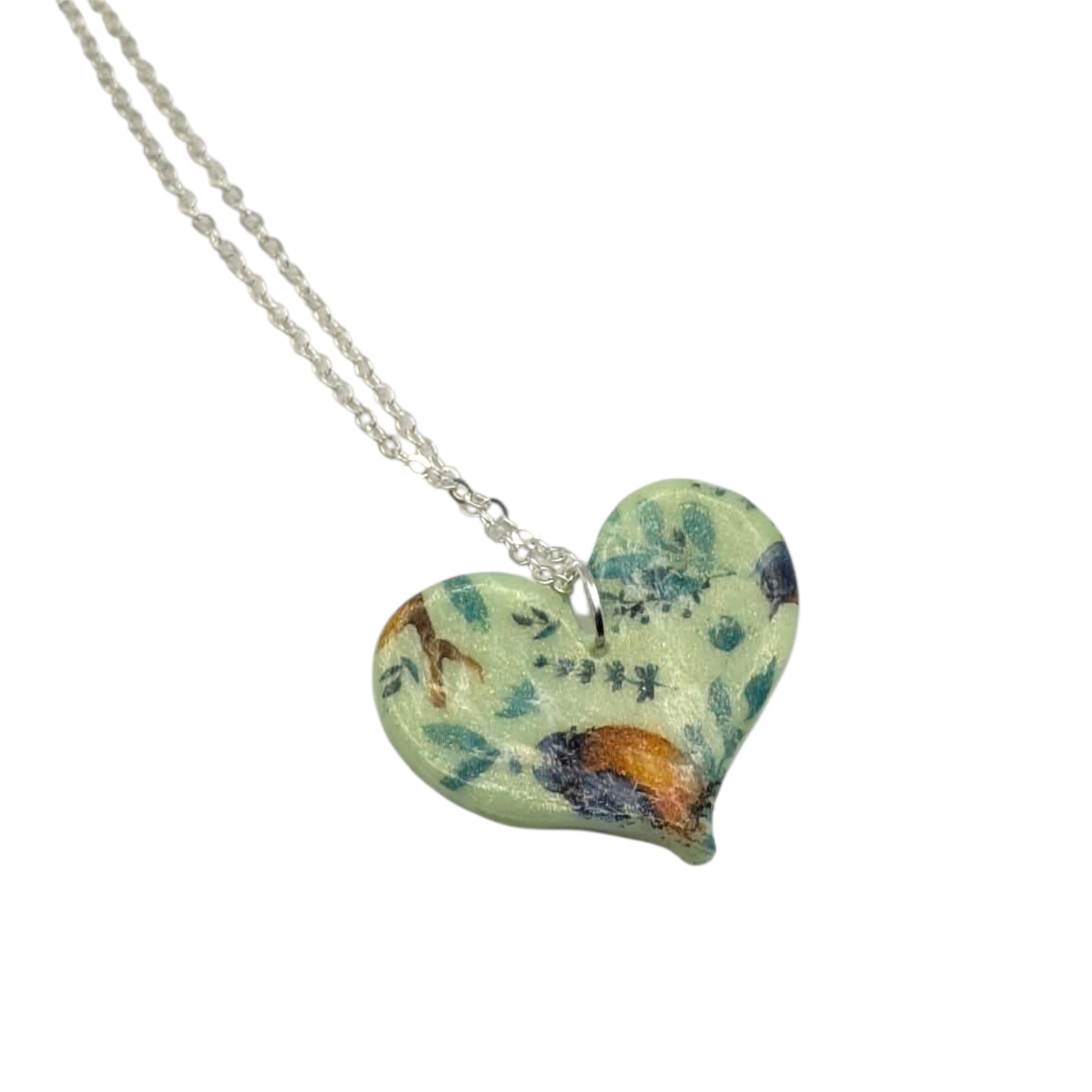 Green botanical bird heart necklace polymer clay handmade jewellery on a white background 