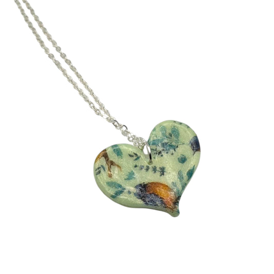 Green botanical bird heart necklace polymer clay handmade jewellery on a white background 