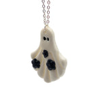 Ghost-shaped pendant with black accents on a white background