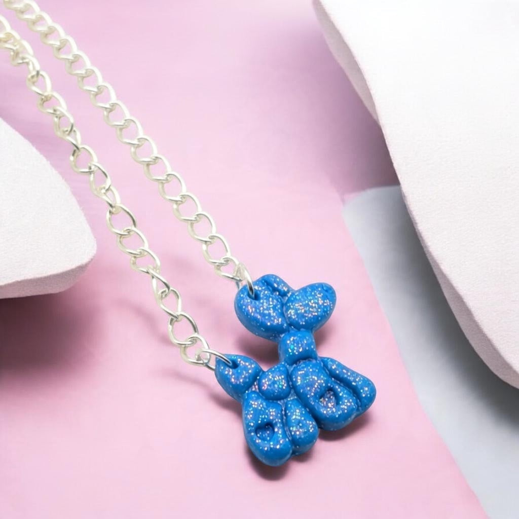 Sparkling blue balloon dog necklace flat lay 