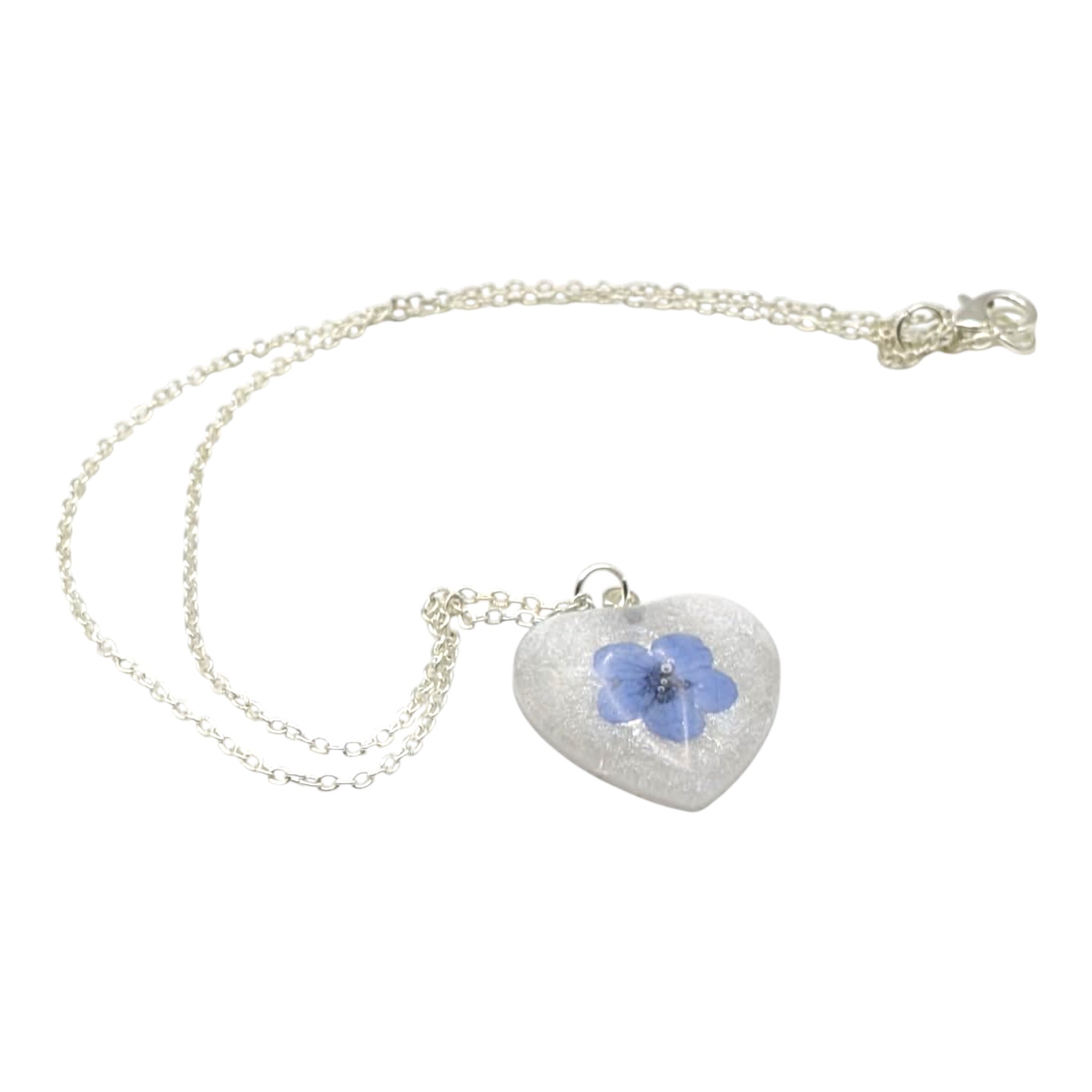 Heart-shaped necklace with a blue flower pendant on a white background