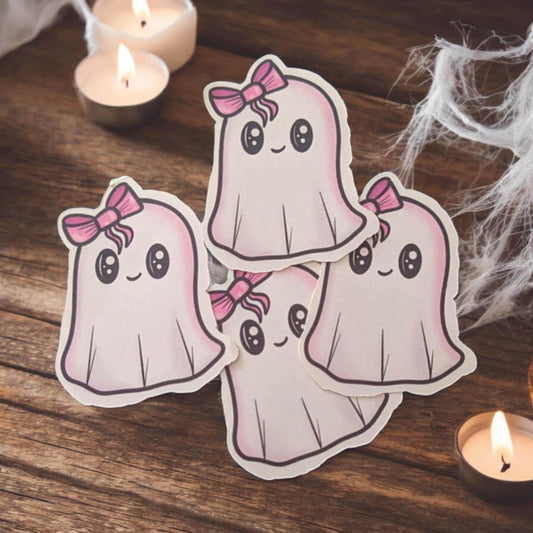 Four cartoon ghosts with pink bows on a wooden surface with candles and spider webs.