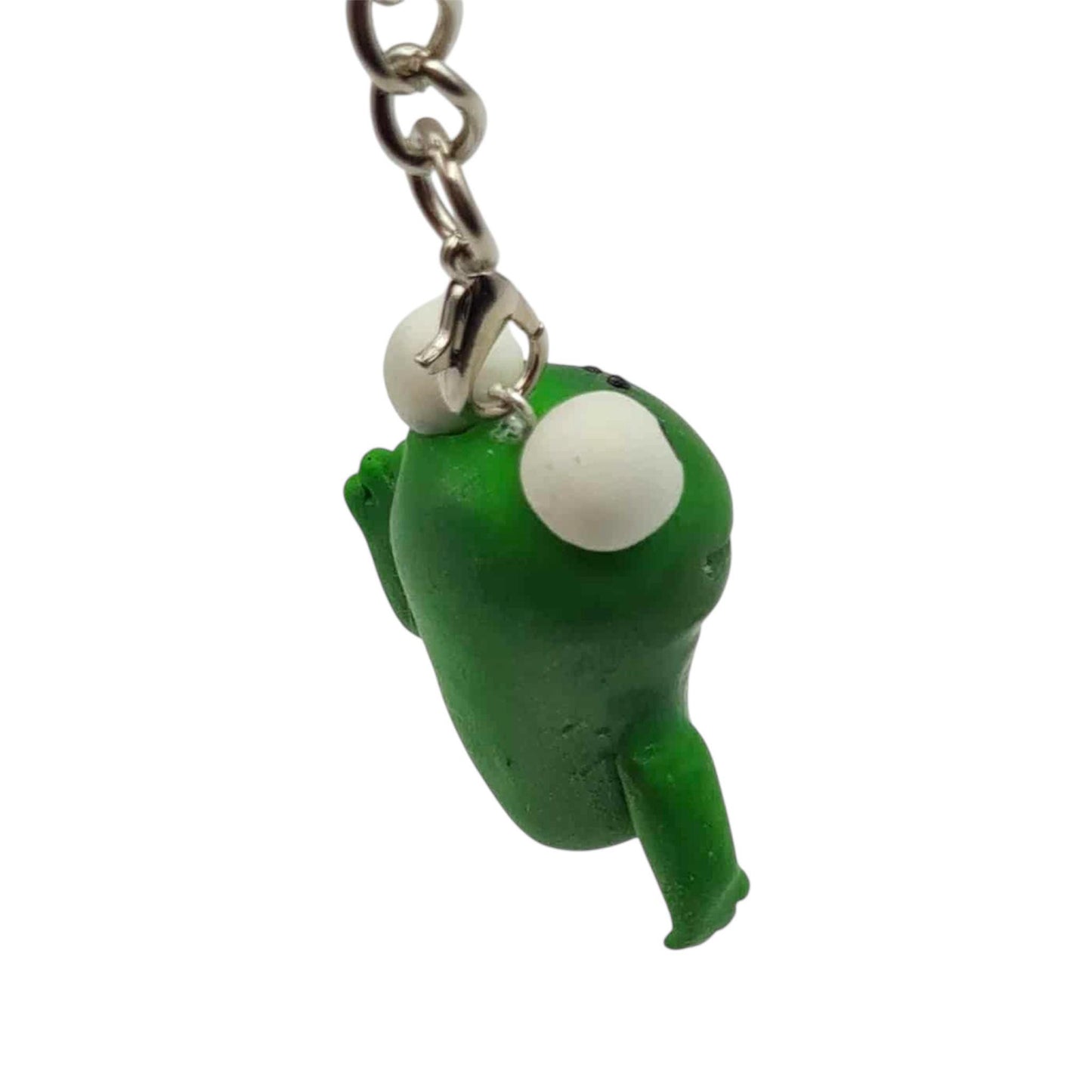 Green character keychain with white spherical eyes on a white background
