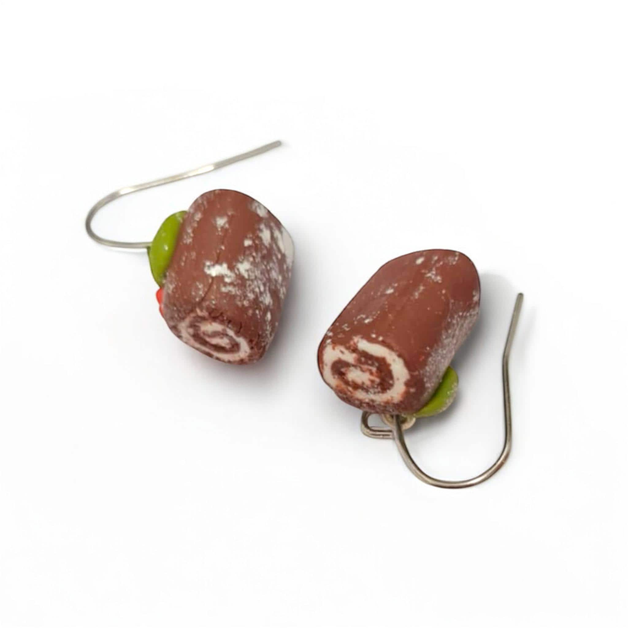 Pair of earrings with brown and green spiral design on a white background