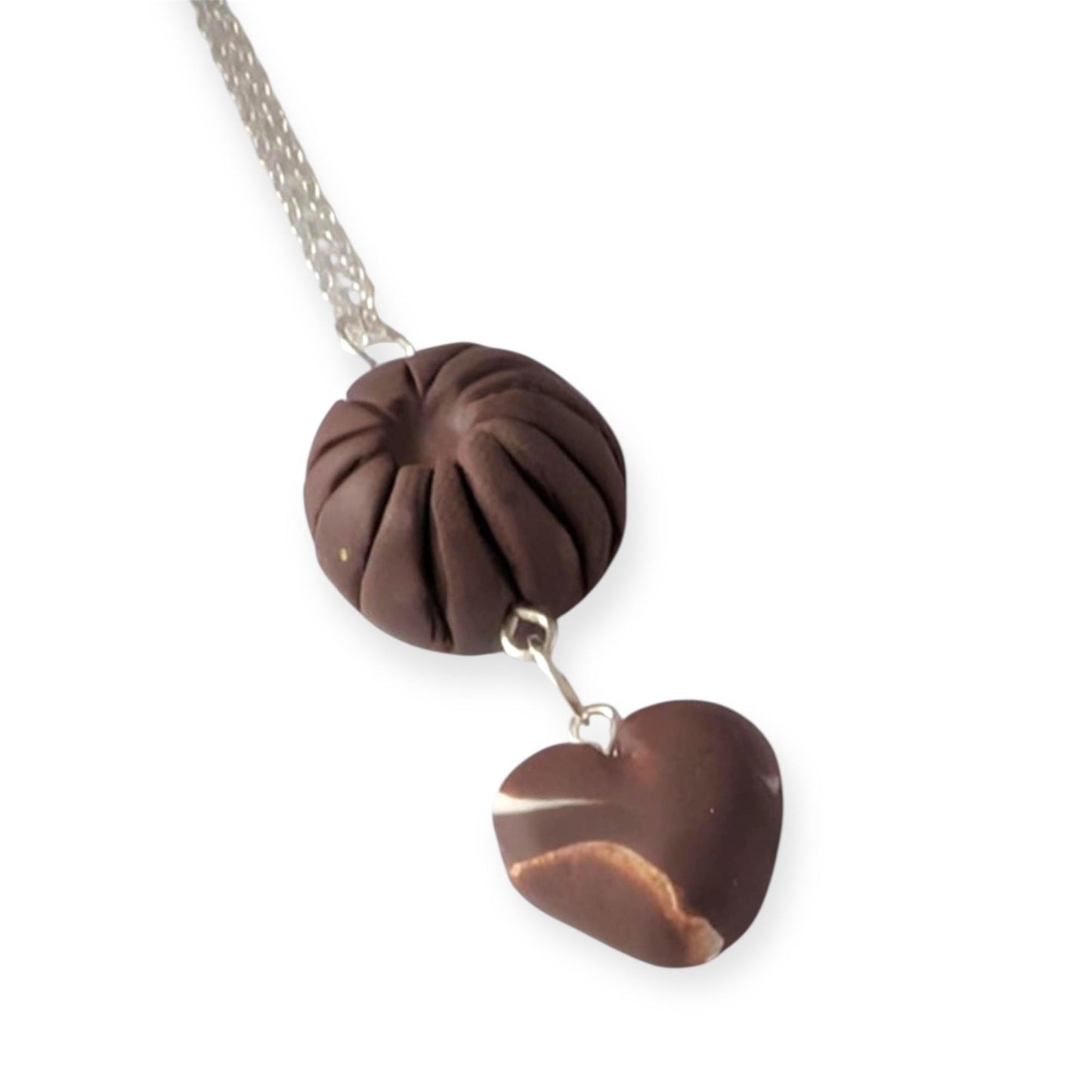Necklace with a brown circular pendant and heart-shaped pendant on a white background