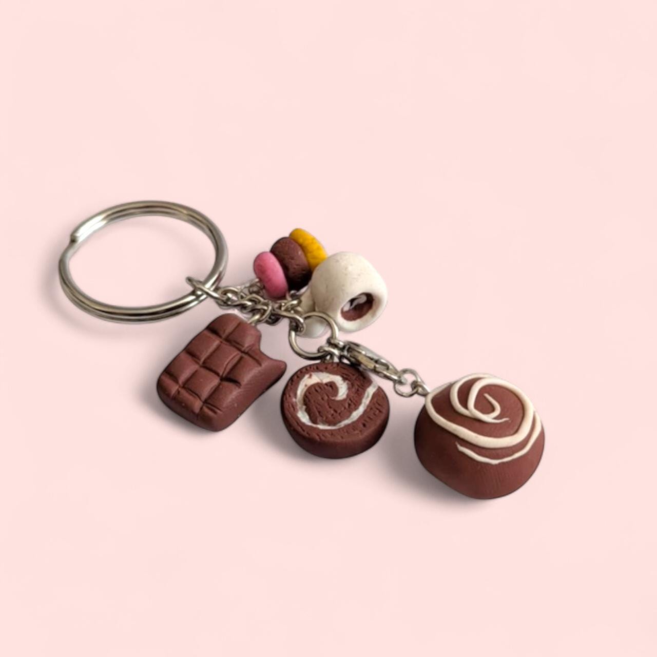 Keychain with chocolate-themed charms on a pink background