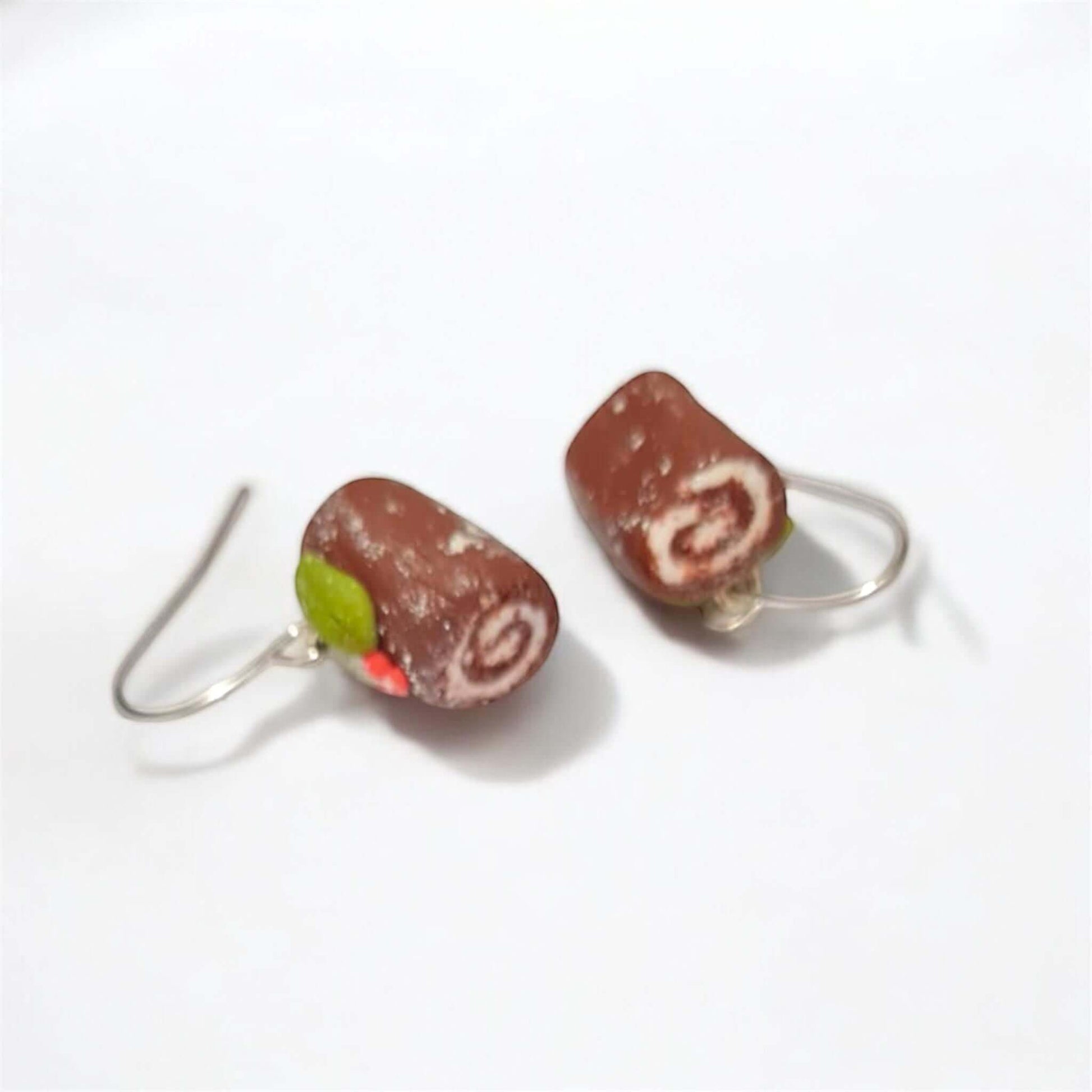 Chocolate roll-shaped earrings on a white background