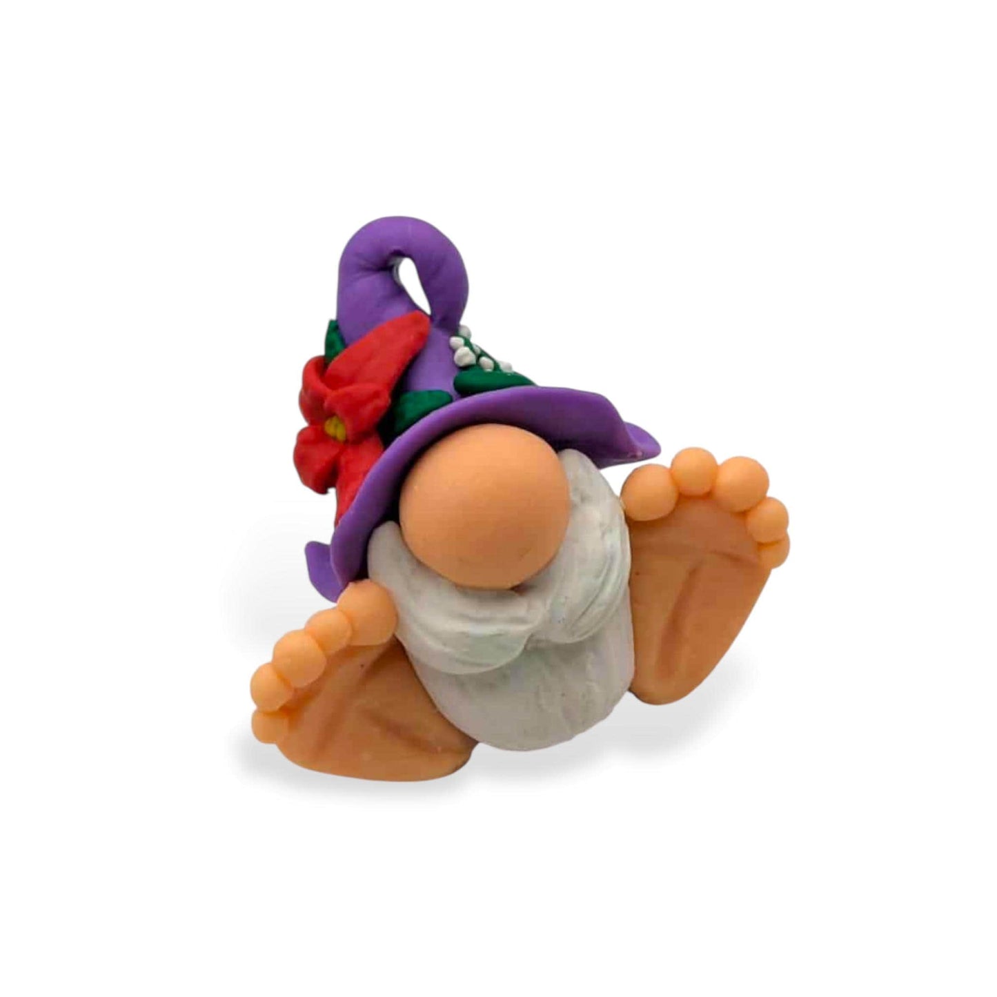 Small figurine of a gnome with a purple hat on a white background