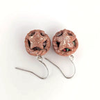 Pair of star-shaped earrings with glittery finish on a white background