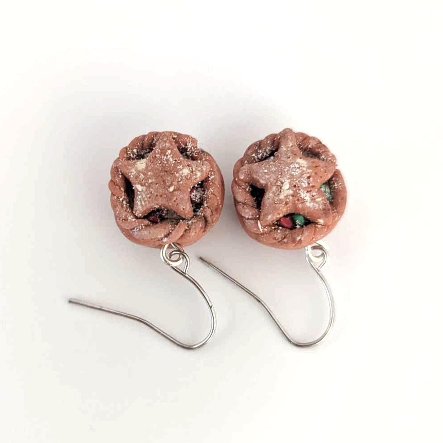 Pair of star-shaped earrings with glittery finish on a white background