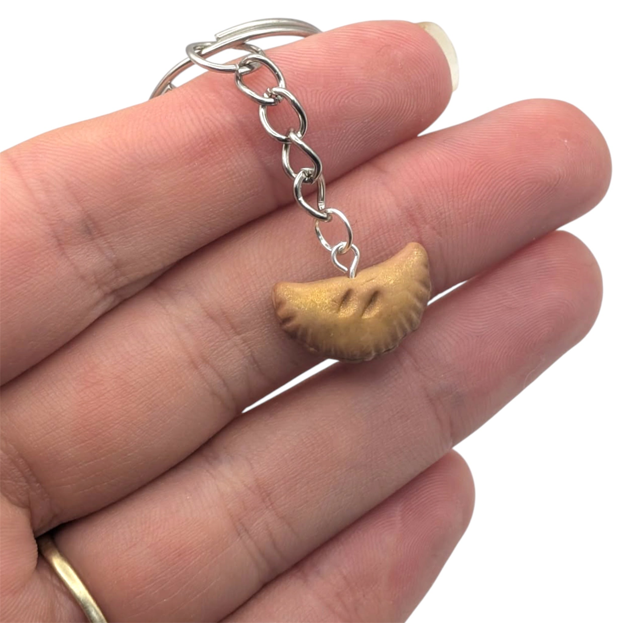 Hand holding small Cornish pasty keychain novelty mini food gift 