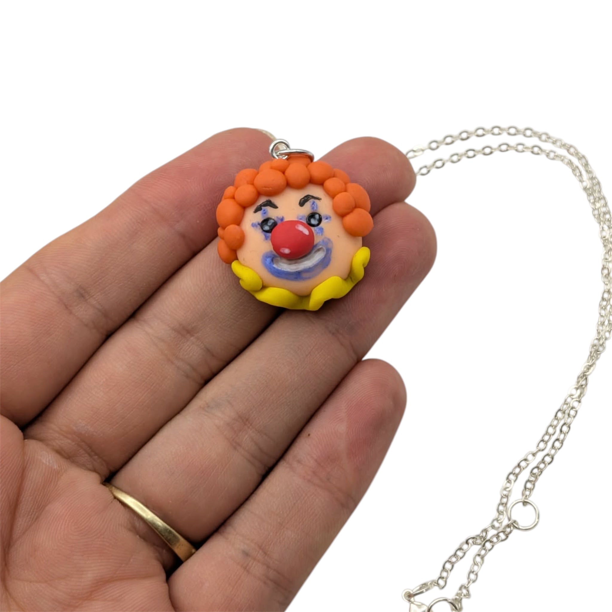 Close-up of the hand-sculpted charm on this clown necklace with silver-plated chain