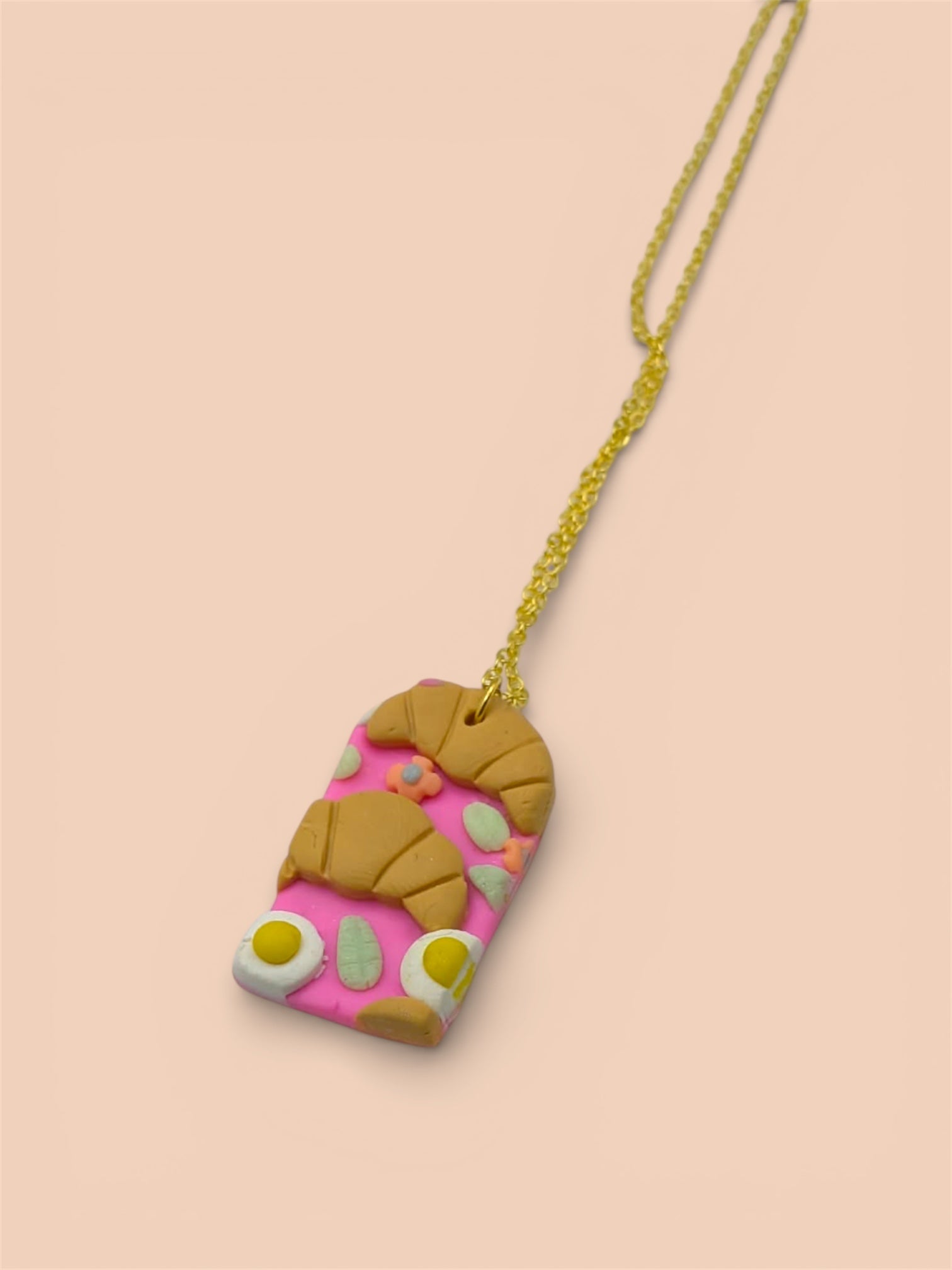 Necklace with a food - shaped pendant on a peach background