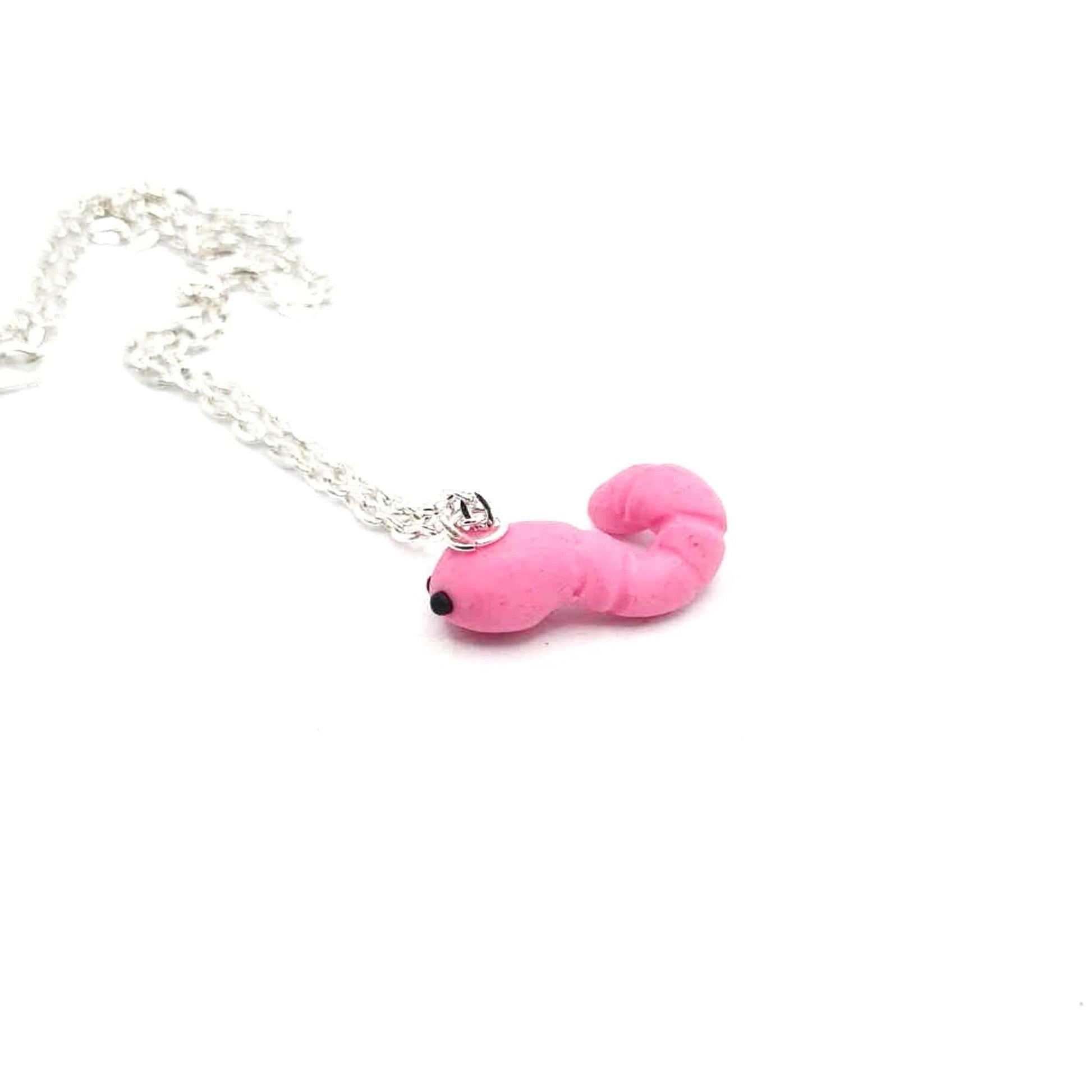 Pink worm-shaped pendant on a silver chain against a white background