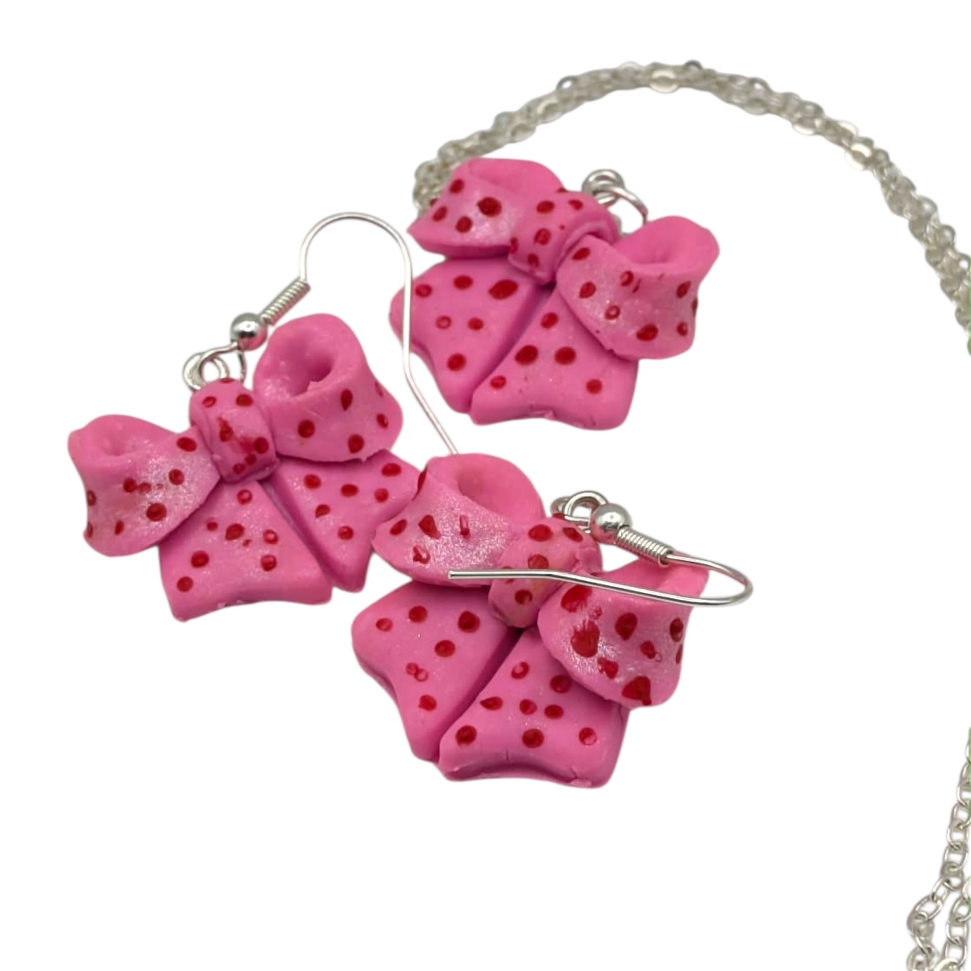 Pink bow necklace and earrings jewellery set on white background 