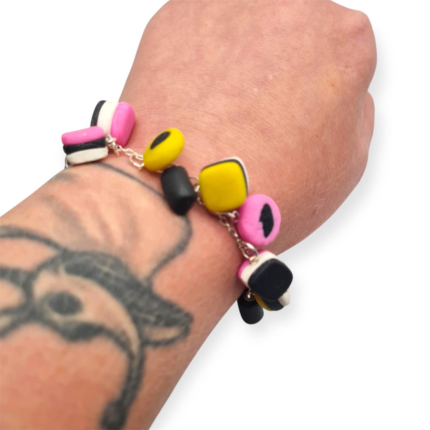 Colourful beaded bracelet on a wrist with a tattoo